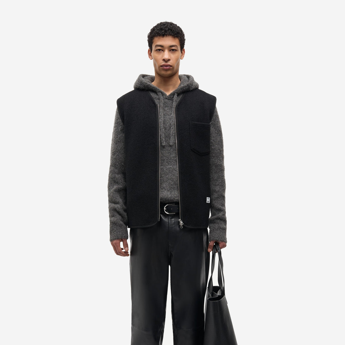 Sahannes vest Black en laine feutrée porté de face sur un hoodie gris et un pantalon en cuir, Samsøe Samsøe