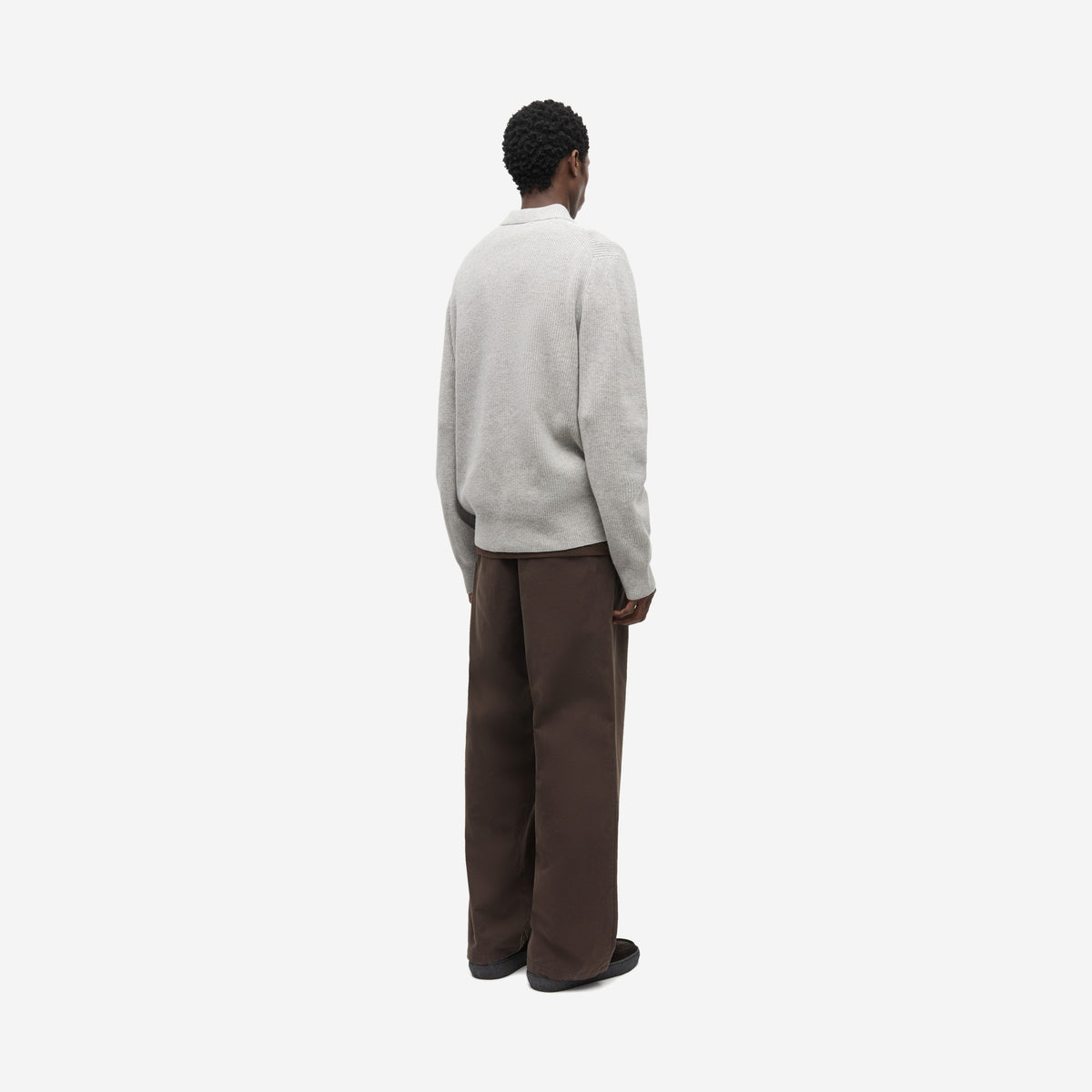 Saisaks HZ Polo Grey Mel. vu de dos et de trois quarts, avec un pantalon brun ample, polo zippé mérinos Samsøe Samsøe